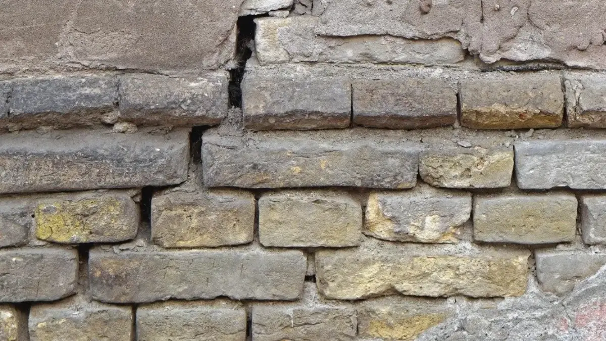 A cracked foundation at the brick line that is sliiping needing immediate repair.