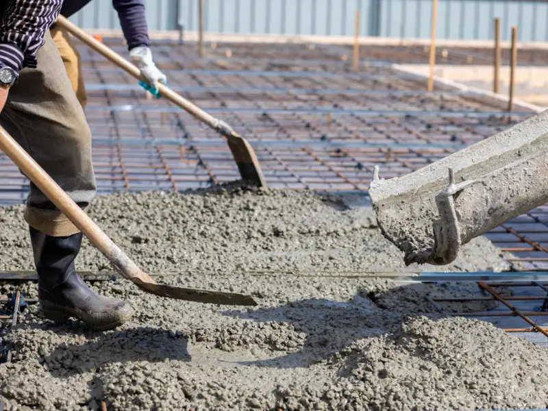 Person spreading concrete.